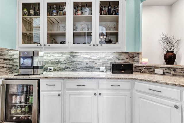 bar featuring white cabinets, backsplash, and beverage cooler