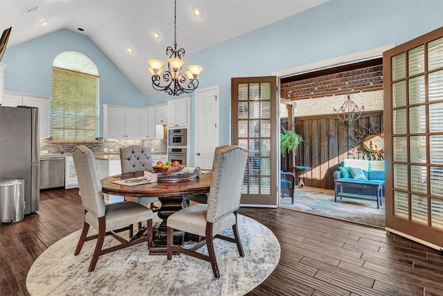 dining room featuring a chandelier, high vaulted ceiling, and dark wood-type flooring