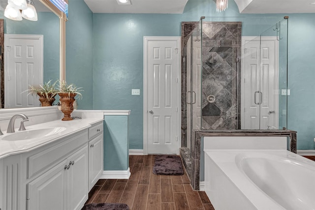 bathroom with vanity, independent shower and bath, and an inviting chandelier