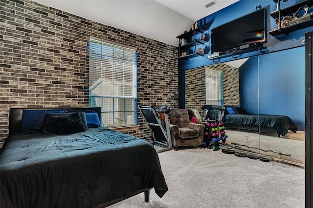 bedroom featuring carpet floors and brick wall