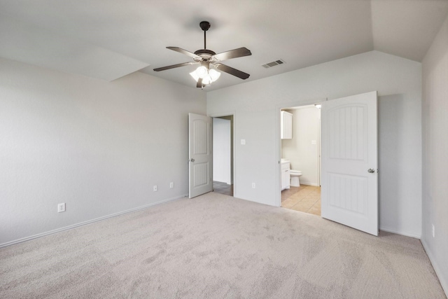 unfurnished bedroom with ensuite bathroom, lofted ceiling, light colored carpet, and ceiling fan