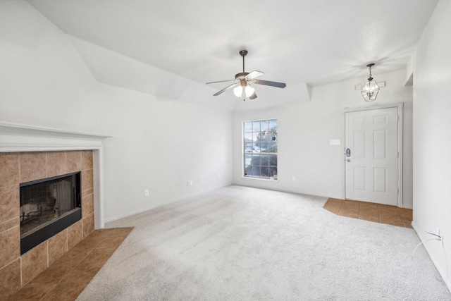 carpeted living room with ceiling fan with notable chandelier and a fireplace