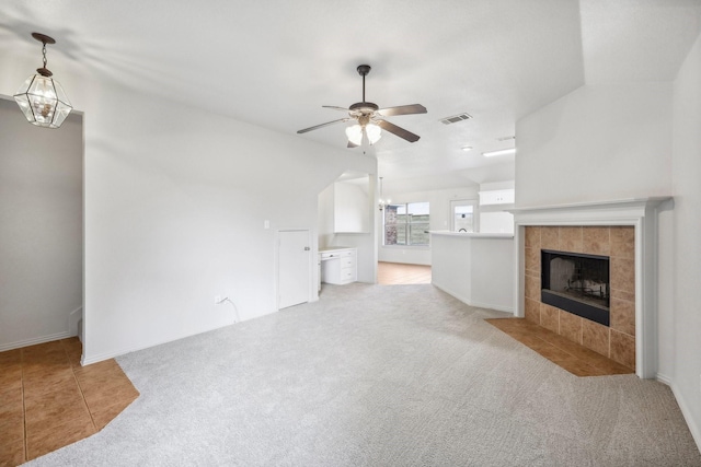 unfurnished living room featuring ceiling fan, light carpet, and a fireplace