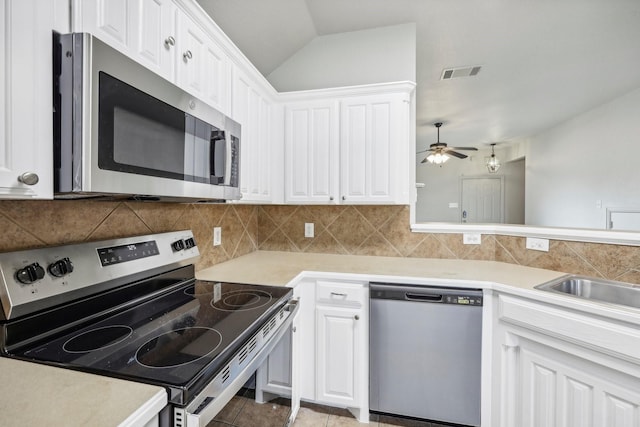 kitchen with white cabinetry, stainless steel appliances, and backsplash