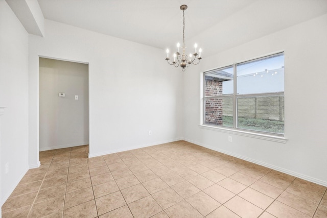 empty room featuring an inviting chandelier and light tile patterned flooring