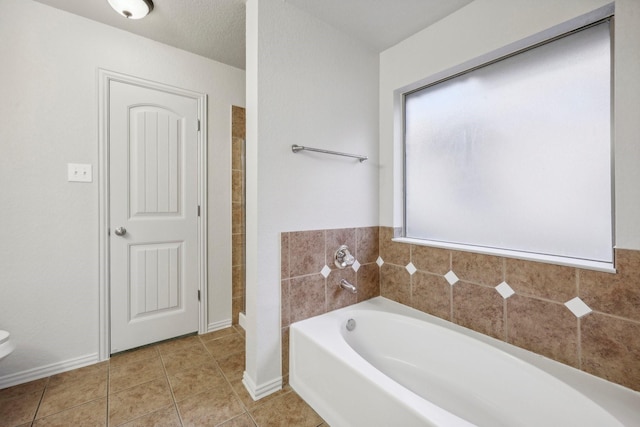 bathroom featuring tile patterned floors and a tub to relax in