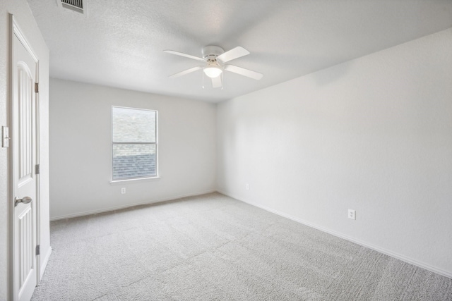 carpeted spare room with a textured ceiling and ceiling fan