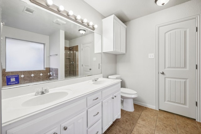 bathroom with vanity, tiled shower, tile patterned floors, and toilet