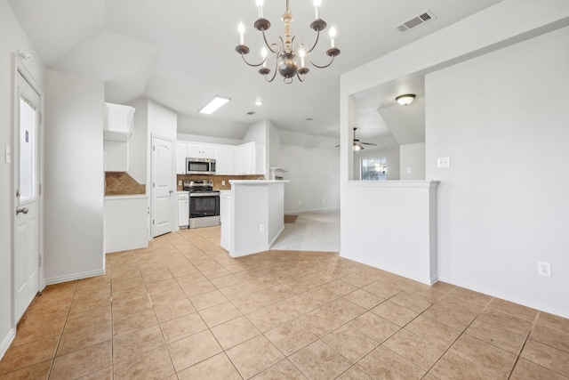 kitchen featuring white cabinetry, tasteful backsplash, vaulted ceiling, appliances with stainless steel finishes, and ceiling fan with notable chandelier