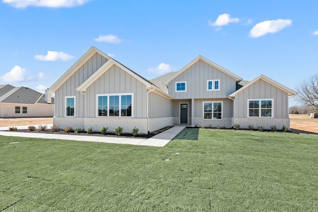 modern farmhouse style home featuring brick siding, board and batten siding, and a front yard