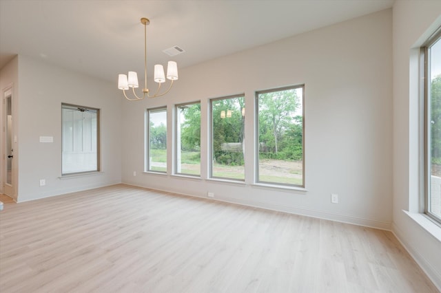 empty room featuring light hardwood / wood-style flooring and a chandelier