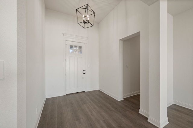 entryway with baseboards, a chandelier, and dark wood-style flooring