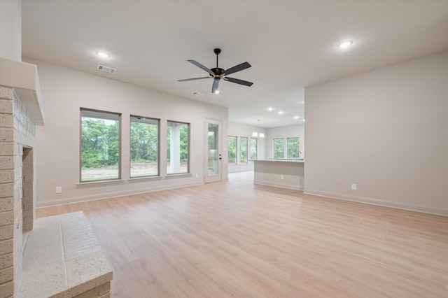 unfurnished living room featuring a fireplace, light hardwood / wood-style flooring, and ceiling fan