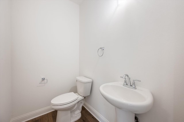 bathroom featuring wood-type flooring, toilet, and sink