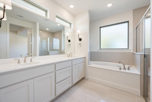 bathroom with tile patterned floors, vanity, and shower with separate bathtub