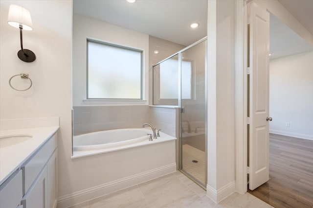 bathroom featuring hardwood / wood-style flooring, vanity, and independent shower and bath