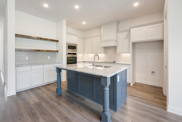 kitchen featuring white cabinets, light stone counters, sink, and appliances with stainless steel finishes