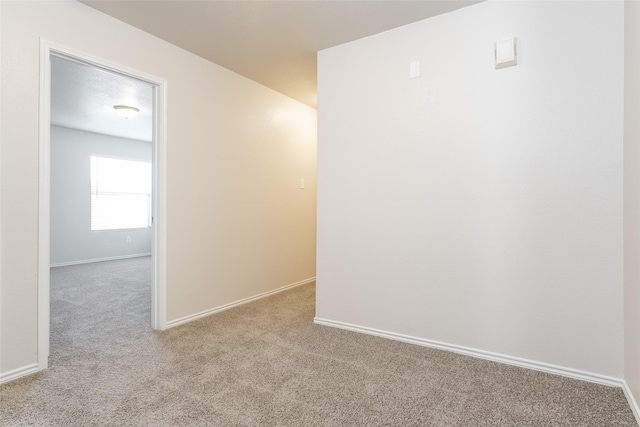 spare room featuring light colored carpet