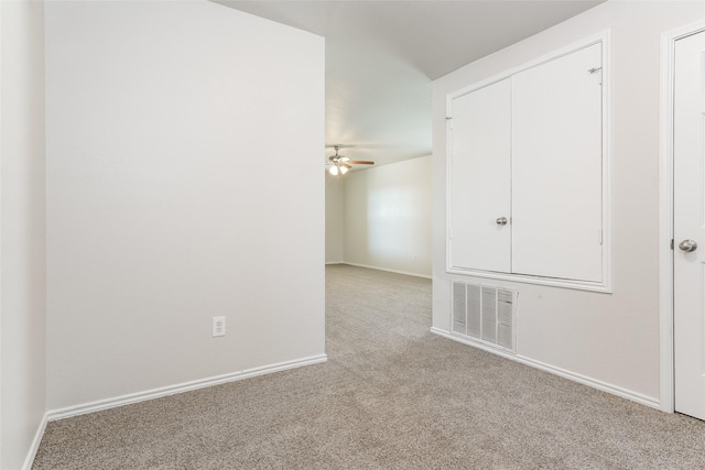 carpeted spare room featuring ceiling fan