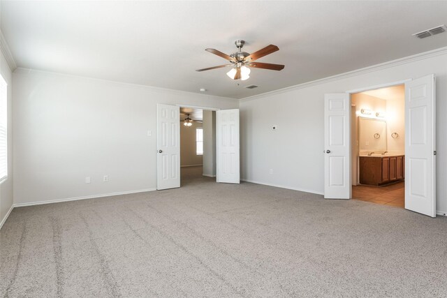 unfurnished bedroom featuring ensuite bathroom, ceiling fan, and light colored carpet