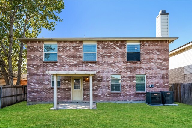 rear view of house with a lawn, a patio area, and central AC unit