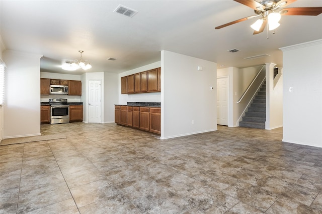 kitchen featuring decorative light fixtures, ceiling fan with notable chandelier, and appliances with stainless steel finishes