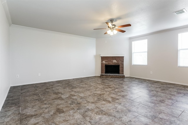 unfurnished living room featuring ceiling fan, a healthy amount of sunlight, ornamental molding, and a brick fireplace