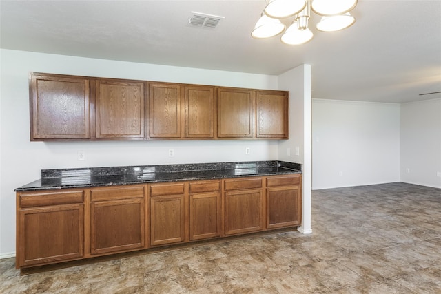 kitchen featuring dark stone countertops and an inviting chandelier