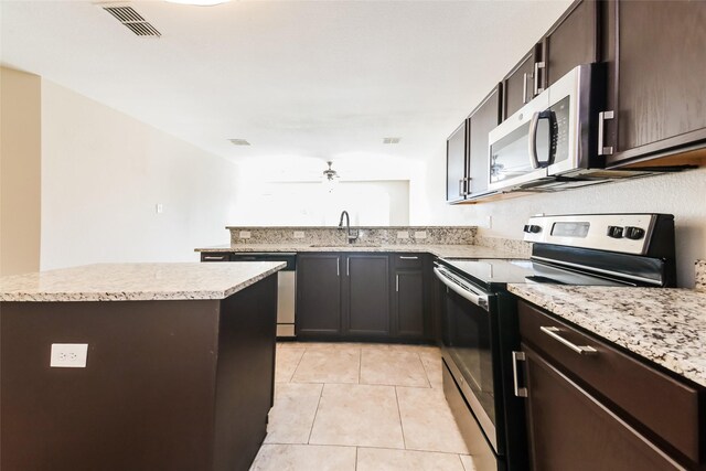 kitchen with a kitchen island, appliances with stainless steel finishes, sink, light tile patterned floors, and kitchen peninsula