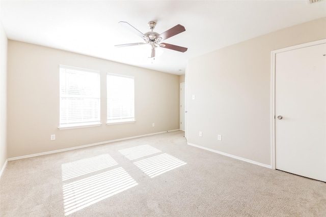 carpeted spare room with ceiling fan