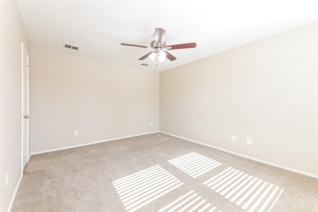 carpeted spare room with ceiling fan