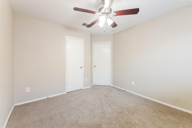 carpeted spare room featuring ceiling fan