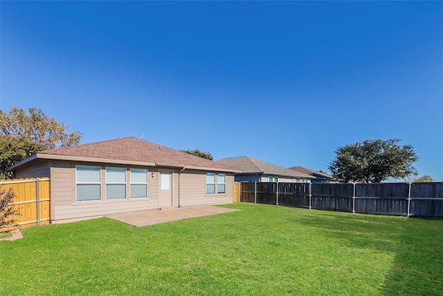 rear view of property featuring a patio and a yard