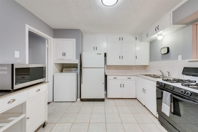 kitchen with a textured ceiling, gas stove, white fridge, washer / clothes dryer, and white cabinetry