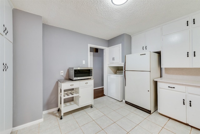 kitchen featuring washer / clothes dryer, white cabinets, white fridge, and a textured ceiling