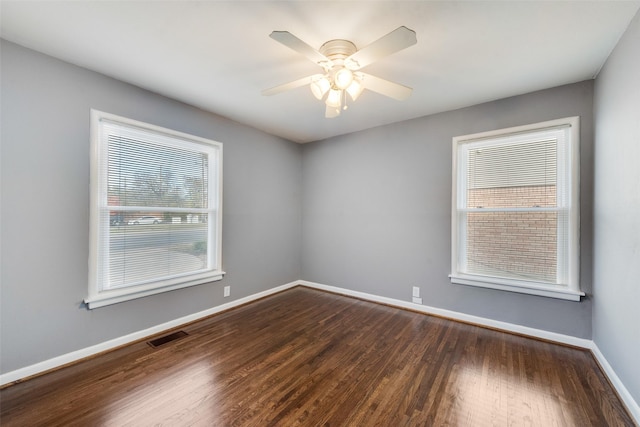 empty room with ceiling fan and dark wood-type flooring