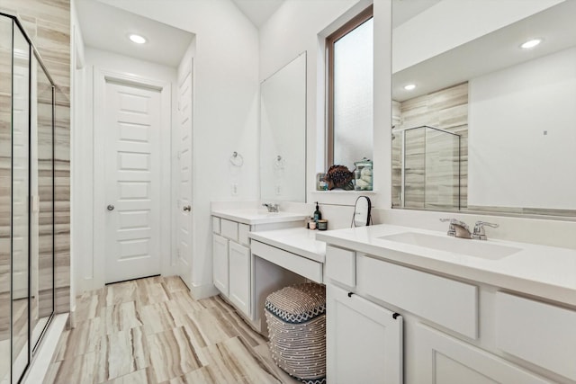 bathroom with a shower with door and vanity