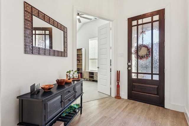 entryway featuring ceiling fan, a healthy amount of sunlight, light wood-type flooring, and vaulted ceiling