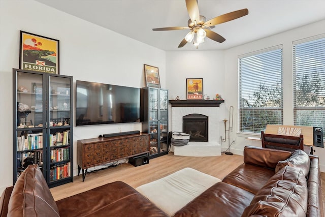 living room with hardwood / wood-style flooring, a brick fireplace, a wealth of natural light, and ceiling fan