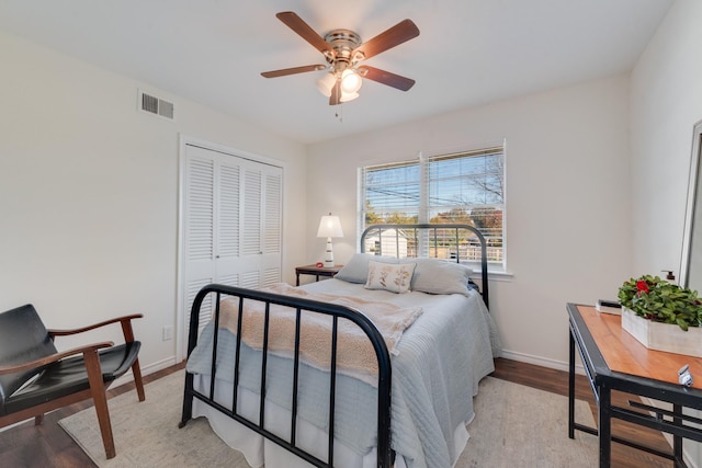 bedroom with ceiling fan, a closet, and light hardwood / wood-style floors