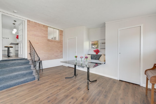 recreation room featuring dark hardwood / wood-style floors and brick wall