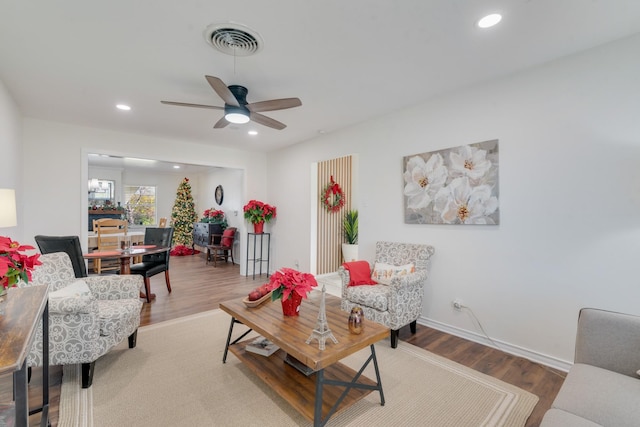 living room with wood-type flooring and ceiling fan