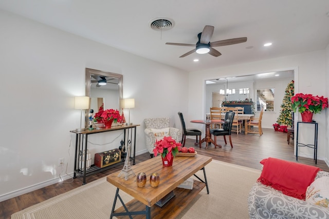 living room with ceiling fan with notable chandelier and wood-type flooring