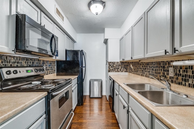 kitchen featuring dark wood-type flooring, electric stove, sink, decorative backsplash, and a textured ceiling