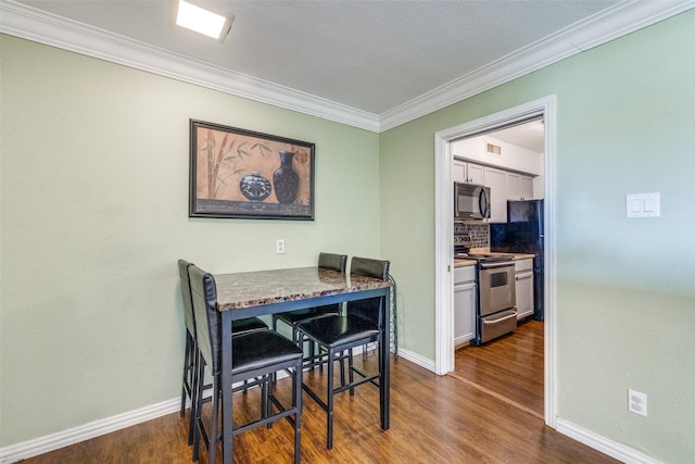 dining area featuring dark hardwood / wood-style floors and crown molding