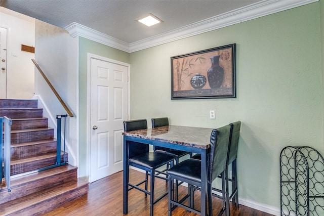 dining space with a textured ceiling, dark hardwood / wood-style floors, and crown molding