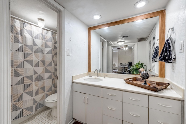 bathroom featuring tile patterned flooring, vanity, toilet, and walk in shower