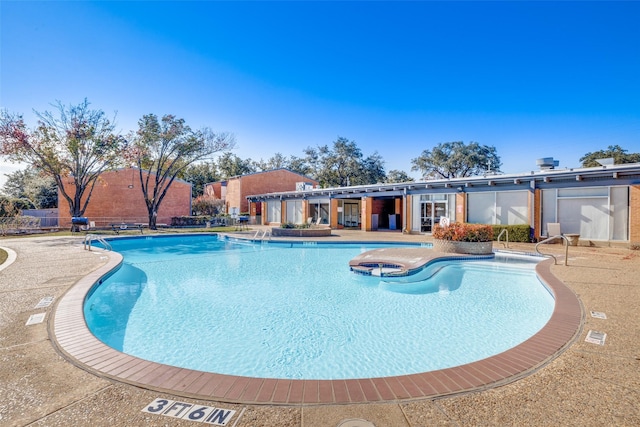 view of pool featuring a patio and a hot tub