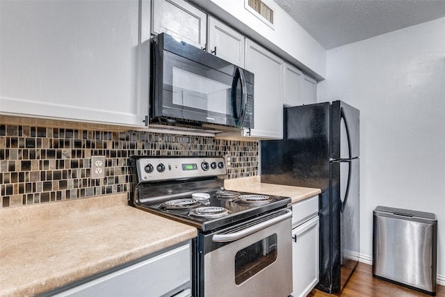 kitchen featuring decorative backsplash, black appliances, and dark hardwood / wood-style floors