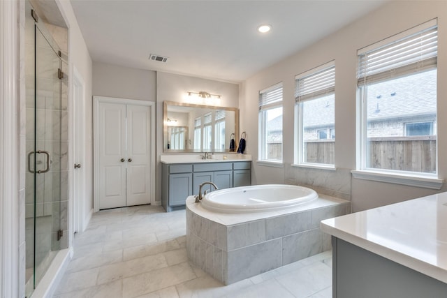 bathroom with tile patterned floors, vanity, and shower with separate bathtub